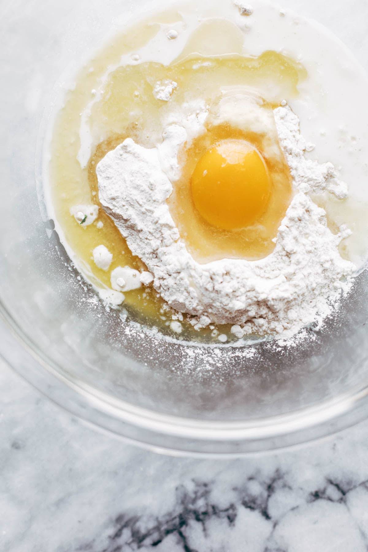 Egg and flour in a bowl for blueberry pancakes.