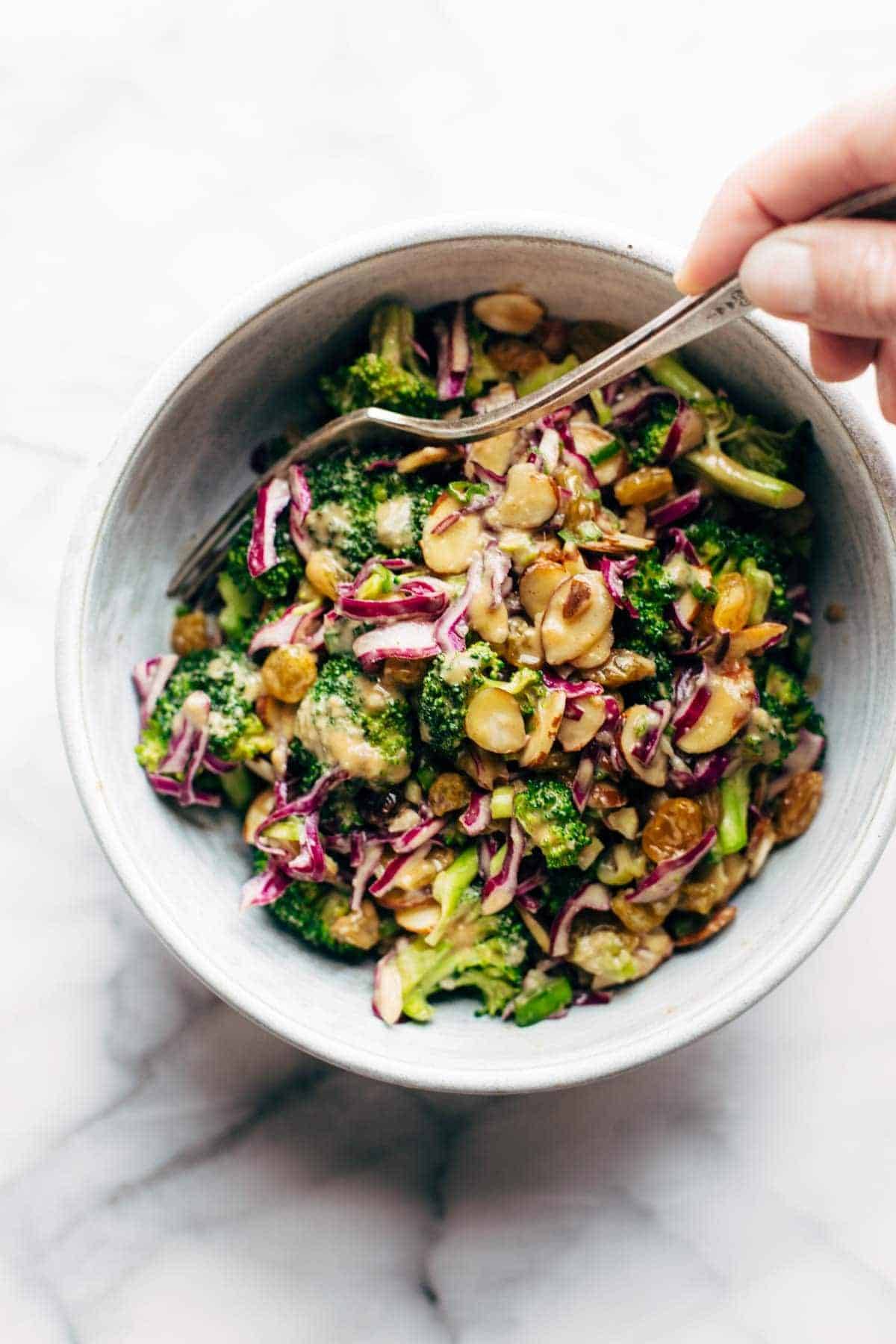 Broccoli salad in a bowl with a fork.