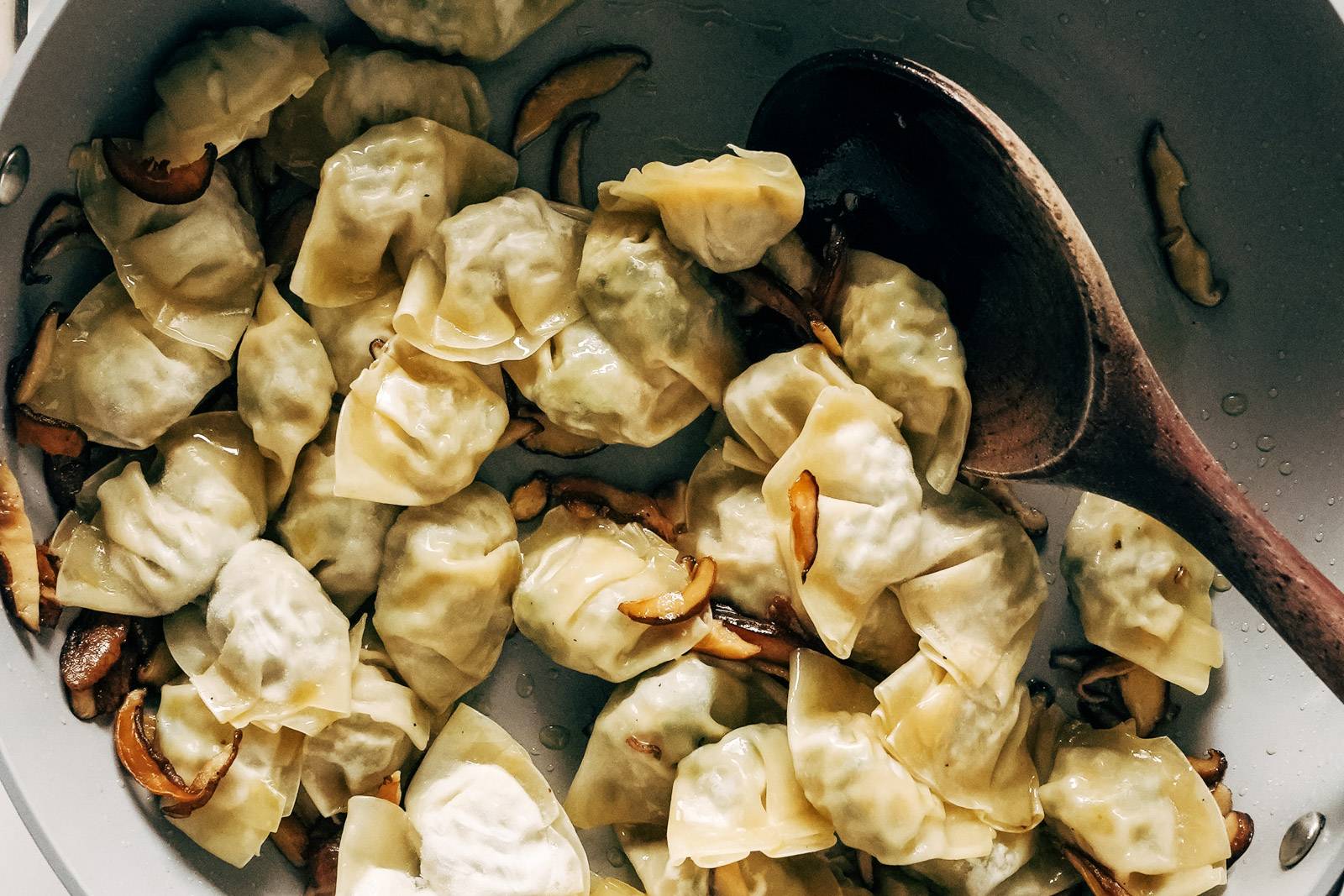 Chicken wontons being sauteed in a pan.