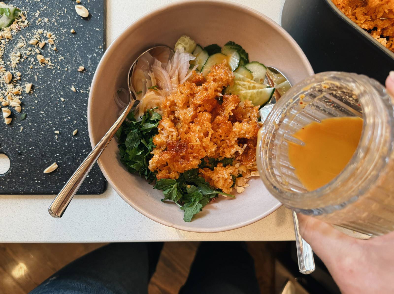 Pouring dressing out of a jar onto a salad.