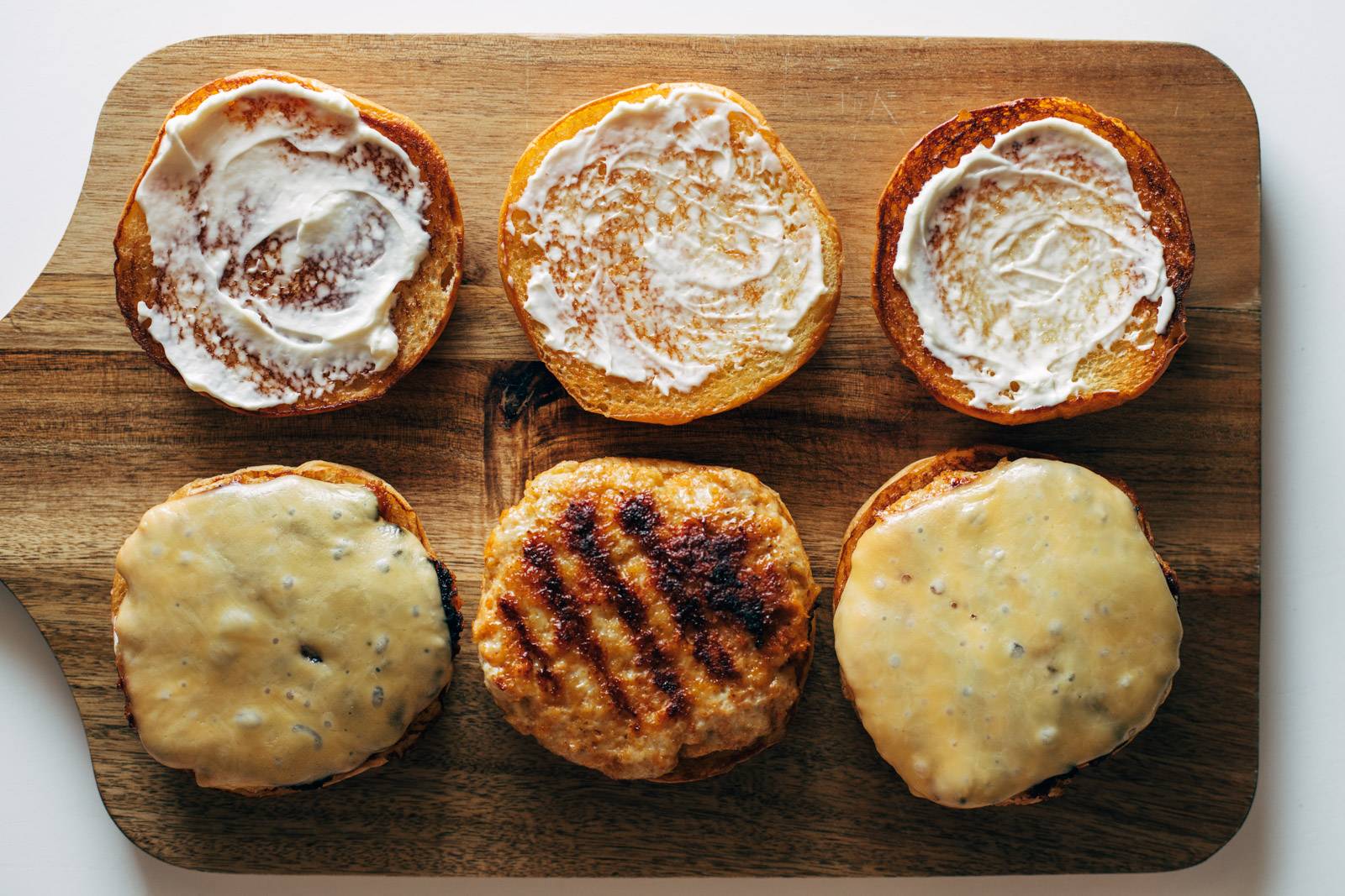 Gochujang burgers being assembled with buns