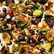 Brussels sprouts on a sheet pan with walnuts and cranberries.