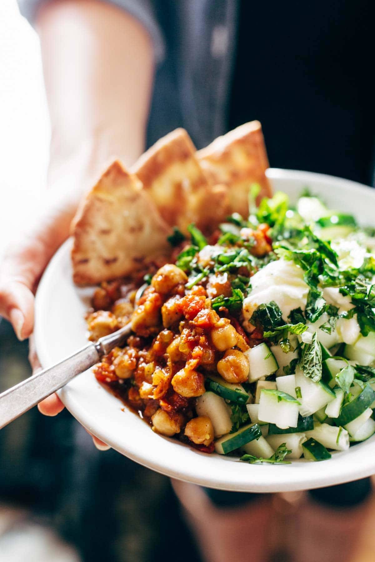 Hands holding Detox Moroccan Chickpea Glow Bowl.