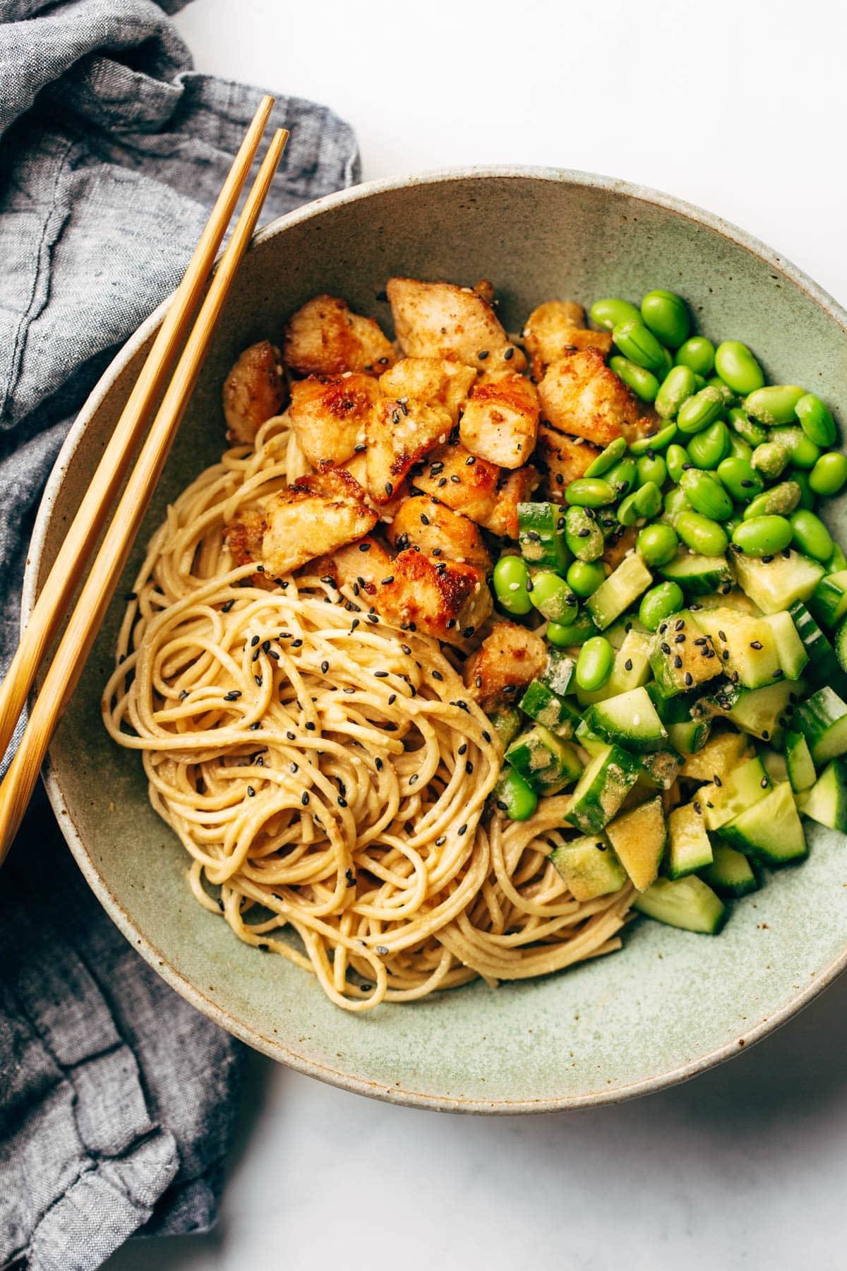 Sesame noodle bowl with chopsticks.